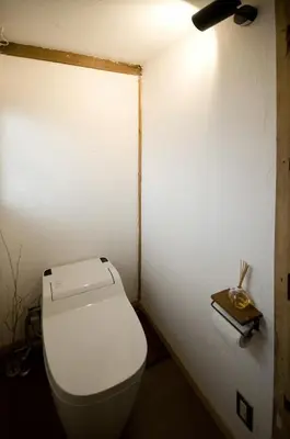 a bathroom with a toilet and a book on the wall at YutoVillageHouse Sweetexperience in Ikebukuro YVM in Tokyo
