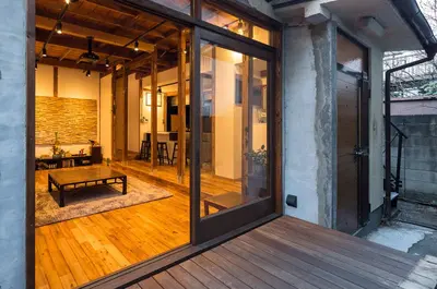 a large glass door on a house with a wooden floor at YutoVillageHouse Sweetexperience in Ikebukuro YVM in Tokyo