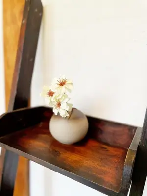 a white vase with flowers sitting on a wooden chair at YutoVillageHouse Sweetexperience in Ikebukuro YVM in Tokyo