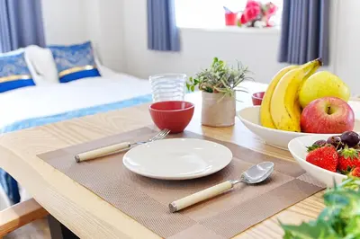 a wooden table with a plate of fruit on it at Unite Stay URAYASU 101 8 minutes by car or 15 minutes by bus to Disneyland in Tokyo