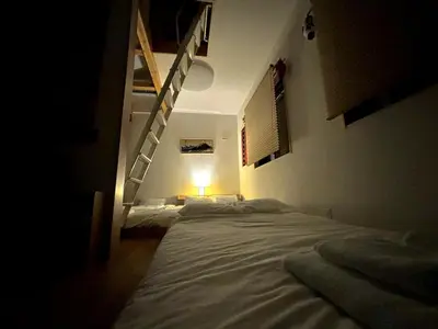 a dark room with a bed and a staircase at Yama Hotel Akabane 201 in Tokyo