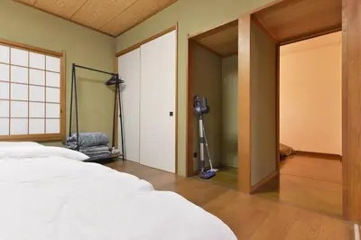 a bedroom with two beds and a camera in a room at Aoi Bld 1F in Tokyo