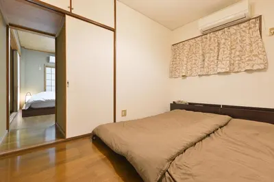 a bedroom with a bed and a window and a mirror at Aoi Bld 1F in Tokyo
