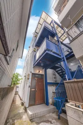 a building with blue stairs in front of a door at Aoi Bld 1F in Tokyo