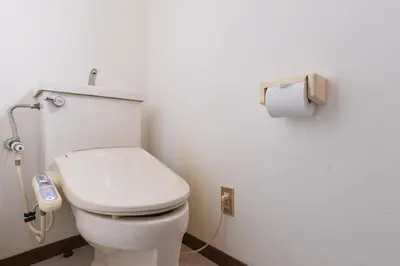 a bathroom with a toilet and a roll of toilet paper at Aoi Bld 2F in Tokyo