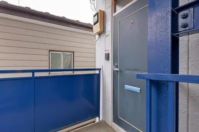 a blue garage door with a blue gate in front of a building at Aoi Bld 2F in Tokyo