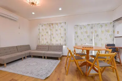 a living room with a couch and a table and chairs at Aoi Bld 2F in Tokyo