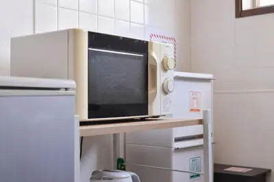 a microwave oven sitting on a counter in a kitchen at Aoi Bld 3F in Tokyo