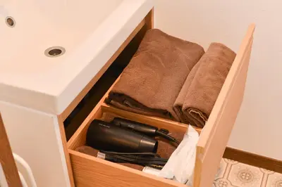 a wooden drawer with a hair dryer and towels at Aoi Bld 3F in Tokyo
