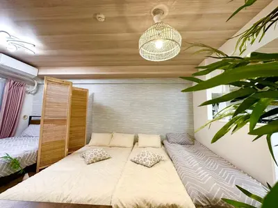 a large bed in a room with a large plant at d402\u6d89\u8c37\u533a\u57df \u4e58\u7535\u8f664\u5206\u949f\u5230\u8fbe\u65b0\u5bbf \u5df4\u58eb\u76f4\u8fbe\u6d89\u8c37\u6b65\u884c\u5230\u897f\u65b0\u5bbf\u4e94\u4e01\u76ee8\u5206\u949f max6 in Tokyo
