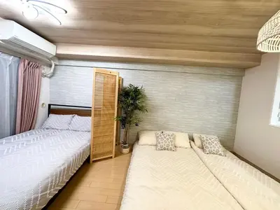 a bedroom with two beds and a potted plant at d402\u6d89\u8c37\u533a\u57df \u4e58\u7535\u8f664\u5206\u949f\u5230\u8fbe\u65b0\u5bbf \u5df4\u58eb\u76f4\u8fbe\u6d89\u8c37\u6b65\u884c\u5230\u897f\u65b0\u5bbf\u4e94\u4e01\u76ee8\u5206\u949f max6 in Tokyo