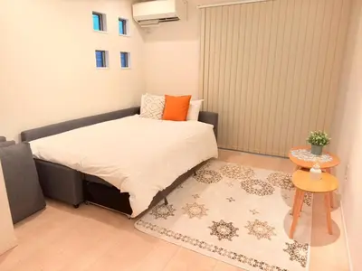 a small bedroom with a bed and a rug at \u6c60\u888b\u946b\u306e\u5c4b in Tokyo
