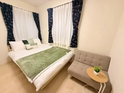 a bedroom with a bed and a chair and a table at \u6c60\u888b\u946b\u306e\u5c4b in Tokyo