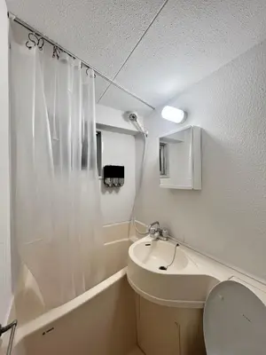 a white bathroom with a toilet and a sink at Higashi-Ikebukuro Japanese Style in Tokyo