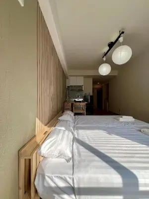 a bedroom with a large bed with white sheets at Higashi-Ikebukuro Japanese Style in Tokyo