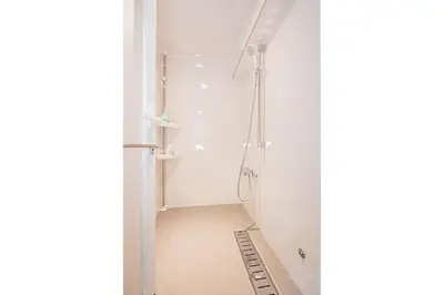 a bathroom with a shower in the corner of a room at \u30a6\u30a3\u30f3\u30b0\u30b2\u30b9\u30c8\u30cf\u30a6\u30b9\u79cb\u8449\u539f301 in Tokyo