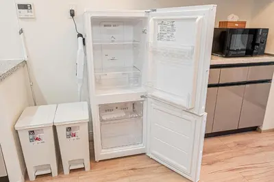 a white refrigerator with its door open in a kitchen at \u30a6\u30a3\u30f3\u30b0\u30b2\u30b9\u30c8\u30cf\u30a6\u30b9\u79cb\u8449\u539f301 in Tokyo