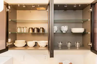 a cabinet filled with plates and bowls on shelves at \u30a6\u30a3\u30f3\u30b0\u30b2\u30b9\u30c8\u30cf\u30a6\u30b9\u79cb\u8449\u539f301 in Tokyo