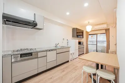 a kitchen with white appliances and a wooden table at \u30a6\u30a3\u30f3\u30b0\u30b2\u30b9\u30c8\u30cf\u30a6\u30b9\u79cb\u8449\u539f301 in Tokyo