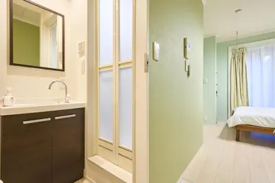 a bathroom with a sink and a mirror and a bed at K2 4min from sta 7min to shinjuku sta quiet area in Tokyo