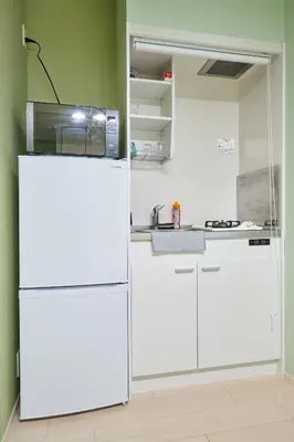 a kitchen with a white refrigerator in a room at K2 4min from sta 7min to shinjuku sta quiet area in Tokyo