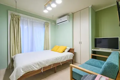 a bedroom with a bed and a tv and a chair at K2 4min from sta 7min to shinjuku sta quiet area in Tokyo
