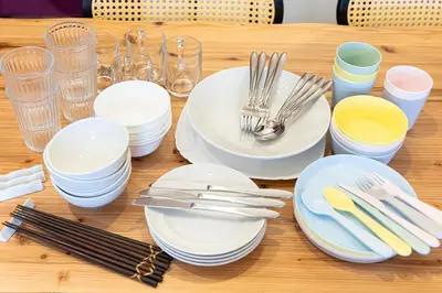 a wooden table with white plates and forks and napkins at \u9580\u524d\u4ef2\u753a\u306e\u685c\u3092\u81e8\u3080\u6c11\u6cca LINKAGE STAY Monzen Nakacho in Tokyo