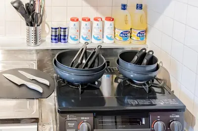 two pots on top of a stove in a kitchen at \u9580\u524d\u4ef2\u753a\u306e\u685c\u3092\u81e8\u3080\u6c11\u6cca LINKAGE STAY Monzen Nakacho in Tokyo