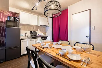 a kitchen with a wooden table and chairs in a kitchen at \u9580\u524d\u4ef2\u753a\u306e\u685c\u3092\u81e8\u3080\u6c11\u6cca LINKAGE STAY Monzen Nakacho in Tokyo