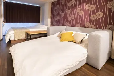 a bedroom with a large white bed with yellow pillows at \u9580\u524d\u4ef2\u753a\u306e\u685c\u3092\u81e8\u3080\u6c11\u6cca LINKAGE STAY Monzen Nakacho in Tokyo