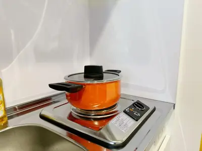 a pot on top of a stove next to a sink at \u7af9\u9db4\u65c5\u9928 in Tokyo
