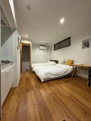 a bedroom with two beds and a wooden floor at \u7af9\u9db4\u65c5\u9928 in Tokyo