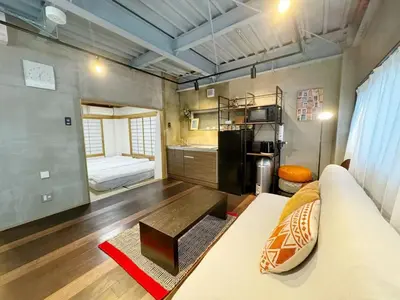 a living room with a couch and a kitchen at \u7af9\u9db4\u65c5\u9928 in Tokyo