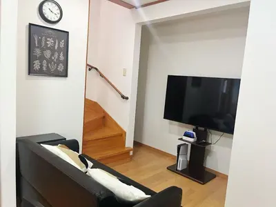 a living room with a black couch and a tv at JW-One Skytree in Tokyo