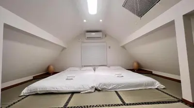 a large white bed in a attic room at JW-One Skytree in Tokyo