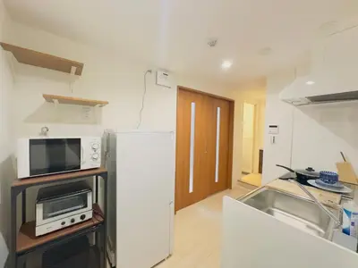 a kitchen with a refrigerator and a microwave at \u963f\u4e45\u6d25\u30cf\u30a4\u30c4102 in Tokyo