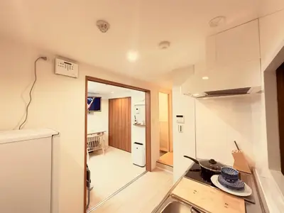 a small kitchen with a counter and a stove in a room at \u963f\u4e45\u6d25\u30cf\u30a4\u30c4102 in Tokyo