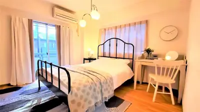 a bedroom with a bed and a desk and a clock at Walking distance to Sunshine, families are welcome and easy to live in in Tokyo