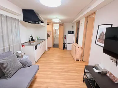 a living room with a couch and a kitchen at Walking distance to Sunshine, families are welcome and easy to live in in Tokyo