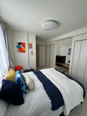 a bedroom with a large bed with blue and white sheets at Private Room with elevator only 2 minutes to station in Tokyo