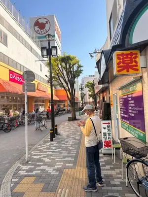 a man standing on a sidewalk looking at his cell phone at Ueno house \u4e0a\u91ce \u72ec\u680b \u8d85\u5927\u6d74\u5ba4 \u548c\u5f0f \u5f69\u8679\u5800\u5207\u83d6\u84b2\u56ed\u7ad9 \u56db\u6728\u7ad9 \u9ad8\u7ea7\u65e5\u5f0f\u5efa\u7b51 \u514d\u8d39\u505c\u8f66\u5834 in Tokyo