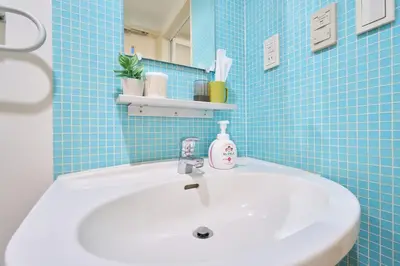 a bathroom with a white sink and blue tiles at 3A SHIBUYA Cozy Bright Apartment, 28sqm, free wifi, MAX 5PP in Tokyo