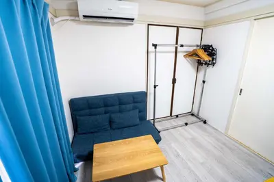 a room with a blue couch and a table at 2 bedrooms and 1 living room on the 1st floor, 40sqm house, 10 min walk to Oji 2 min walk to Kajiyara Toden Arakawa Line in Wada