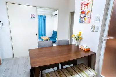 a dining room with a wooden table and chairs at 2 bedrooms and 1 living room on the 1st floor, 40sqm house, 10 min walk to Oji 2 min walk to Kajiyara Toden Arakawa Line in Wada