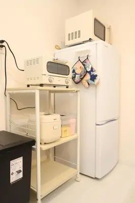 a kitchen with a microwave and a refrigerator at \u30d5\u30a3\u30e6\u30d5\u30e9\u30c3\u30c4\u9326\u7cf8\u753a 101 \u30b9\u30ab\u30a4\u30c4\u30ea\u30fc\u307e\u3067\u5f92\u6b6910\u5206 in Tokyo