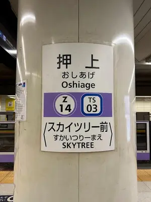 a sign on a pillar in a train station at \u30d5\u30a3\u30e6\u30d5\u30e9\u30c3\u30c4\u9326\u7cf8\u753a 101 \u30b9\u30ab\u30a4\u30c4\u30ea\u30fc\u307e\u3067\u5f92\u6b6910\u5206 in Tokyo