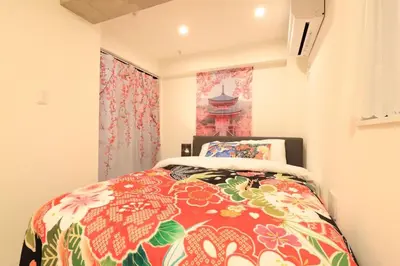 a bedroom with a bed with a colorful bedspread at \u30d5\u30a3\u30e6\u30d5\u30e9\u30c3\u30c4\u9326\u7cf8\u753a 101 \u30b9\u30ab\u30a4\u30c4\u30ea\u30fc\u307e\u3067\u5f92\u6b6910\u5206 in Tokyo