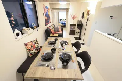 a room with a table and chairs in a room at \u30d5\u30a3\u30e6\u30d5\u30e9\u30c3\u30c4\u9326\u7cf8\u753a 101 \u30b9\u30ab\u30a4\u30c4\u30ea\u30fc\u307e\u3067\u5f92\u6b6910\u5206 in Tokyo