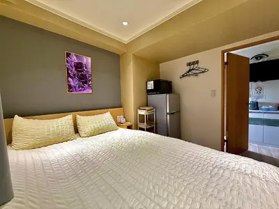 a bedroom with a large bed and a refrigerator at 32A Ikebukuro, 2 bedrooms and 1 living room, 7 mins to ST Max 4P \u6c60\u888b \u5168\u65b0\u88c5\u4fee \u4e24\u5ba4\u4e00\u5385 \u4ea4\u901a\u4e2d\u5fc3 \u8f66\u7ad97\u5206\u949f \u6700\u59274\u4eba \u76f4\u8fbe\u65b0\u5bbf \u6d89\u8c37 \u8868\u53c2\u9053 \u54c1\u5ddd \u6c60\u888b \u4e0a\u91ce \u4ee3\u4ee3\u6728 \u94f6\u5ea7 \u539f\u5bbf in Tokyo