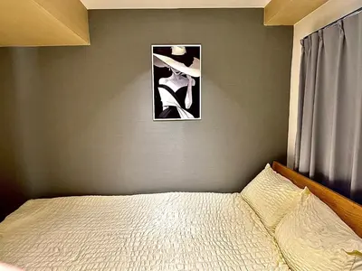 a bedroom with a bed with a picture on the wall at 32A Ikebukuro, 2 bedrooms and 1 living room, 7 mins to ST Max 4P \u6c60\u888b \u5168\u65b0\u88c5\u4fee \u4e24\u5ba4\u4e00\u5385 \u4ea4\u901a\u4e2d\u5fc3 \u8f66\u7ad97\u5206\u949f \u6700\u59274\u4eba \u76f4\u8fbe\u65b0\u5bbf \u6d89\u8c37 \u8868\u53c2\u9053 \u54c1\u5ddd \u6c60\u888b \u4e0a\u91ce \u4ee3\u4ee3\u6728 \u94f6\u5ea7 \u539f\u5bbf in Tokyo
